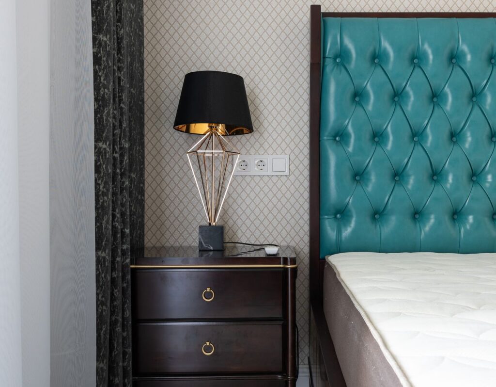 Mastering the First Impression: Your intriguing post title goes here Modern bedroom interior with lamp between mattress on bed with upholstery and curtains at home